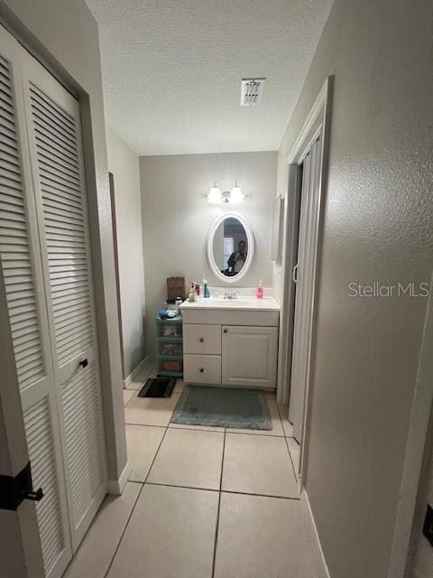 bathroom featuring tile patterned floors, vanity, and a textured ceiling