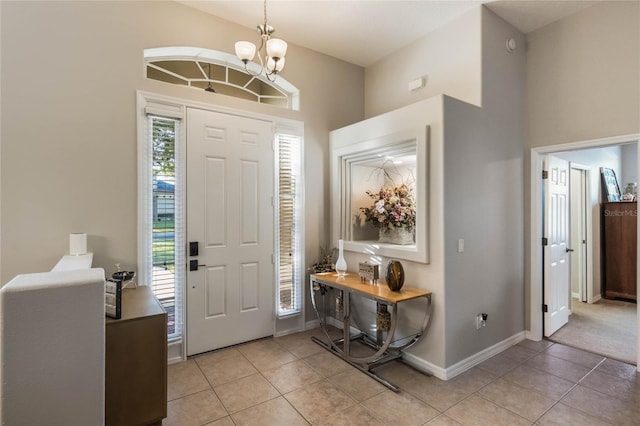 foyer with plenty of natural light, light tile patterned floors, and an inviting chandelier