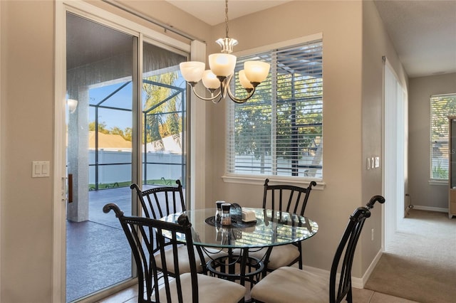 dining area featuring a wealth of natural light, light colored carpet, and a notable chandelier