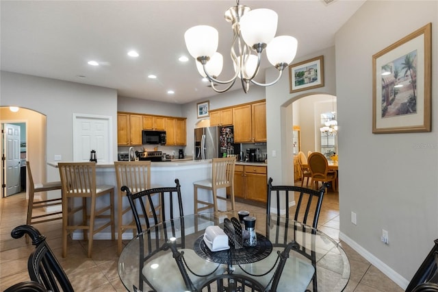 dining area with light tile patterned floors and a notable chandelier