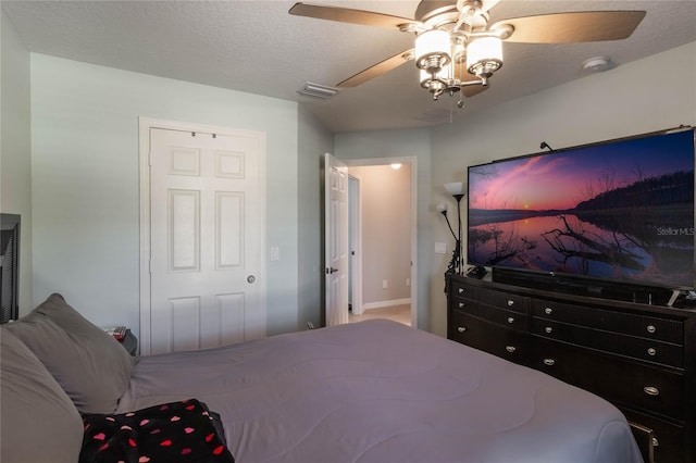 bedroom featuring ceiling fan, a closet, and a textured ceiling