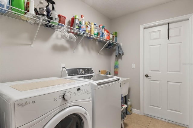 washroom featuring washing machine and clothes dryer and light tile patterned floors