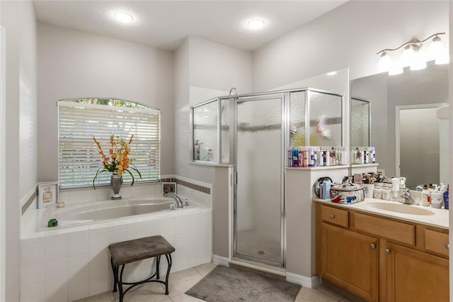 bathroom featuring tile patterned flooring, vanity, a textured ceiling, and plus walk in shower