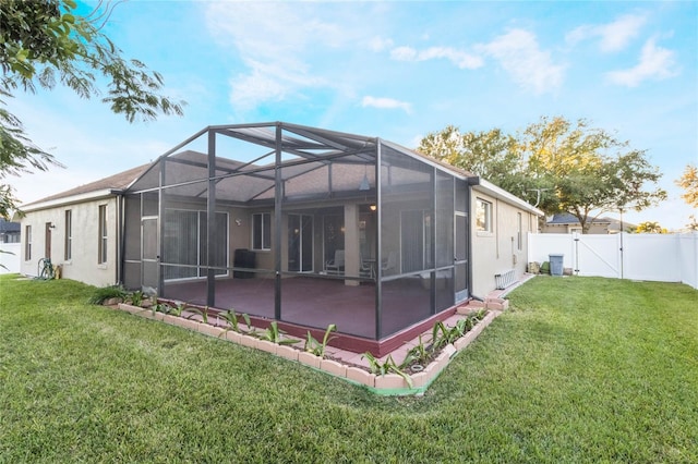 back of property featuring a patio area, a yard, and glass enclosure