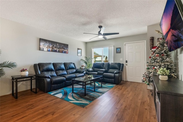 living room with a textured ceiling, hardwood / wood-style flooring, and ceiling fan