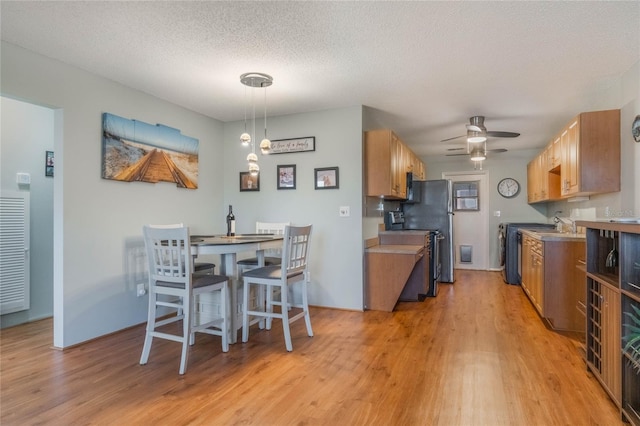 kitchen featuring stainless steel range with electric stovetop, light hardwood / wood-style flooring, ceiling fan, a textured ceiling, and decorative light fixtures