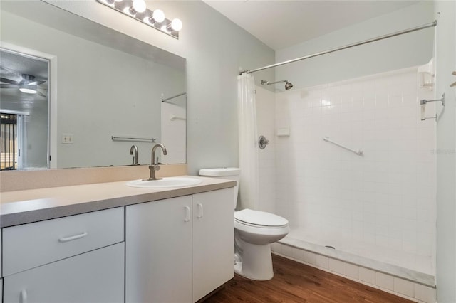 bathroom featuring hardwood / wood-style floors, vanity, toilet, and curtained shower