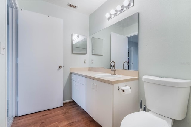 bathroom featuring vanity, hardwood / wood-style flooring, and toilet