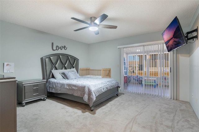 bedroom featuring ceiling fan, light carpet, and a textured ceiling