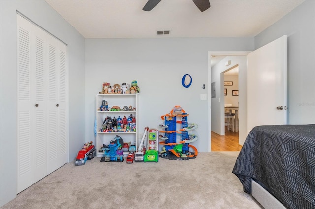 carpeted bedroom featuring ceiling fan and a closet