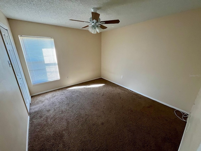 spare room featuring carpet flooring, ceiling fan, and a textured ceiling