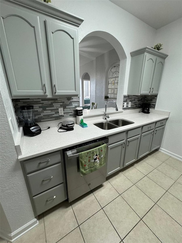 kitchen with backsplash, dishwasher, light tile patterned floors, and sink