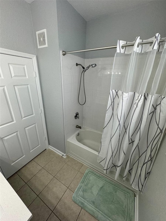 bathroom with tile patterned floors and shower / bath combo with shower curtain