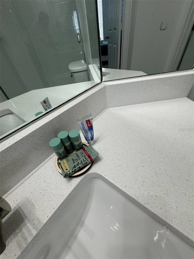 interior details featuring toilet and an enclosed shower