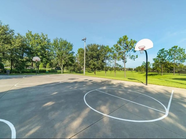 view of basketball court with a yard