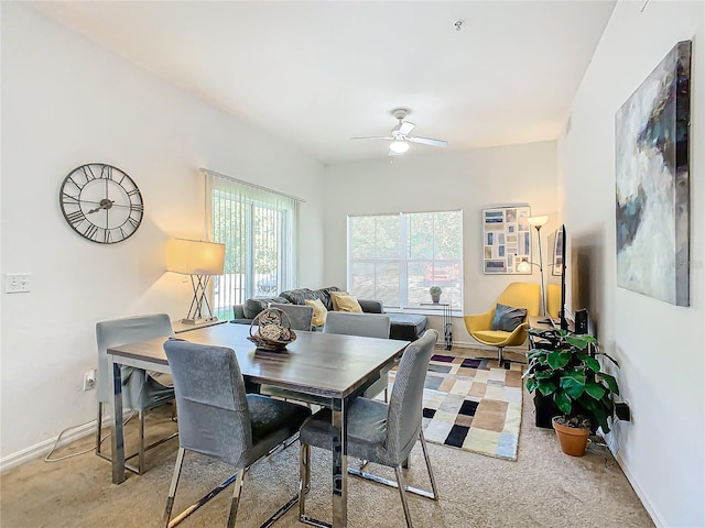 carpeted dining room with ceiling fan