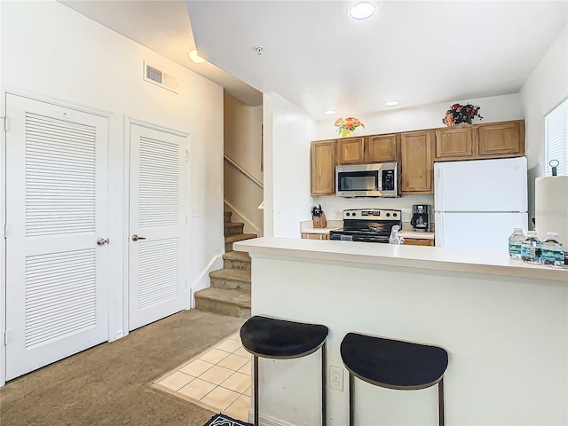 kitchen featuring kitchen peninsula, a breakfast bar, and appliances with stainless steel finishes