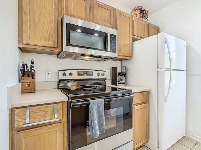 kitchen with light tile patterned flooring and appliances with stainless steel finishes