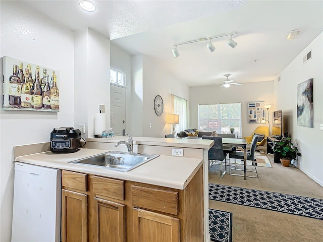 kitchen with dishwasher, track lighting, sink, ceiling fan, and kitchen peninsula