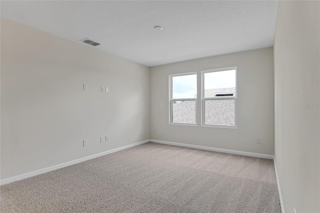 carpeted spare room featuring a textured ceiling