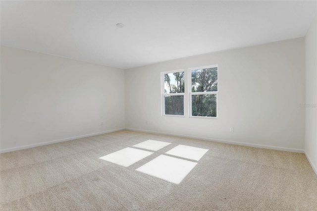 unfurnished room featuring light colored carpet