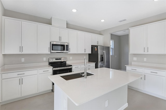 kitchen with sink, a center island with sink, white cabinets, and appliances with stainless steel finishes