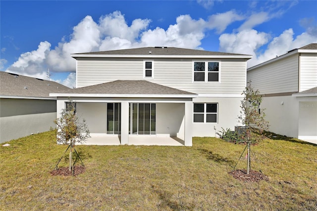 back of property with a lawn and a patio