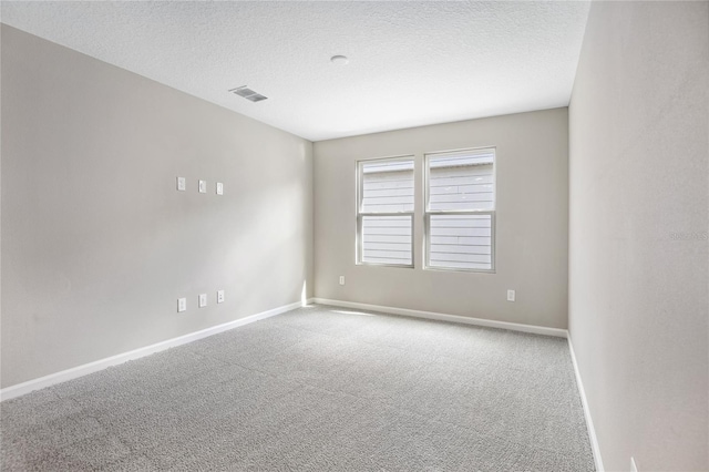 spare room featuring carpet floors and a textured ceiling