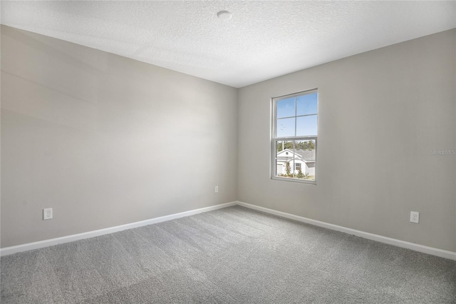 carpeted spare room featuring a textured ceiling