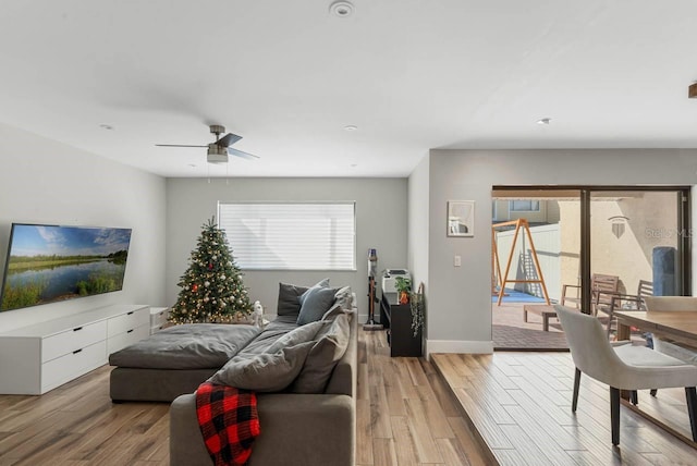 living room with light wood-type flooring, plenty of natural light, and ceiling fan