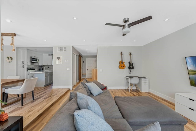 living room featuring light hardwood / wood-style flooring and ceiling fan