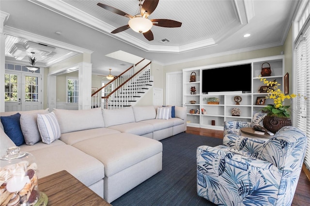 living room with dark hardwood / wood-style floors, a raised ceiling, crown molding, and french doors