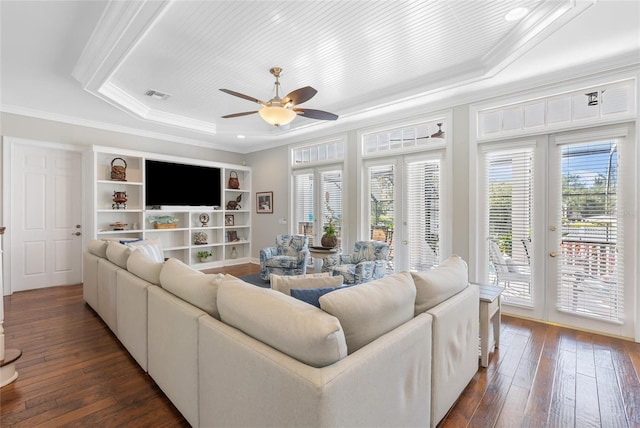 living room featuring ceiling fan, french doors, a raised ceiling, dark hardwood / wood-style floors, and crown molding