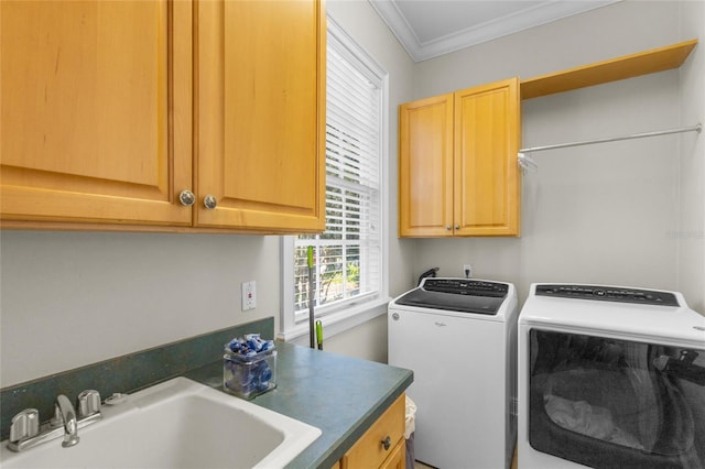 clothes washing area with cabinets, washing machine and clothes dryer, ornamental molding, and sink