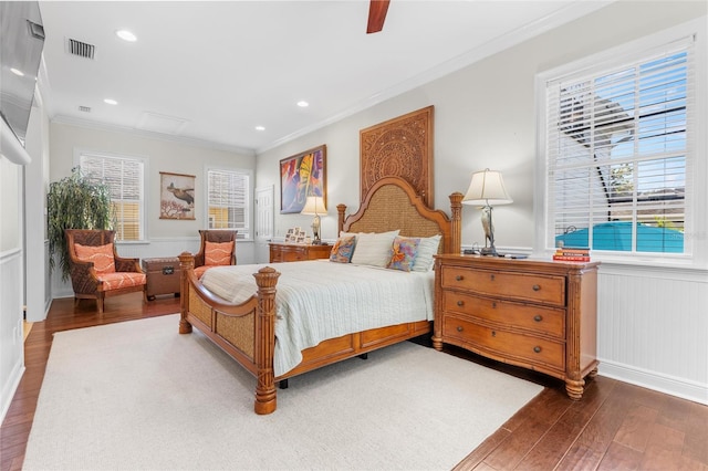 bedroom featuring ceiling fan, wood-type flooring, crown molding, and multiple windows