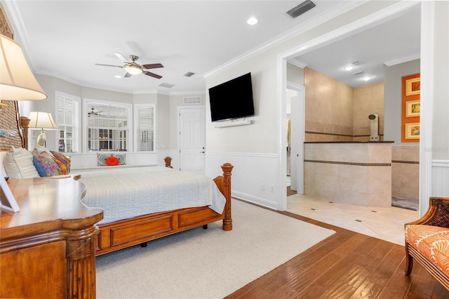 bedroom with ceiling fan, light hardwood / wood-style floors, crown molding, and tile walls