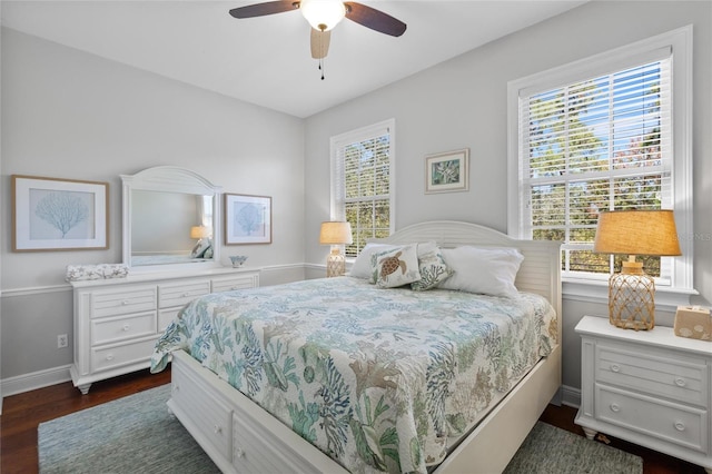 bedroom featuring dark hardwood / wood-style flooring, multiple windows, and ceiling fan