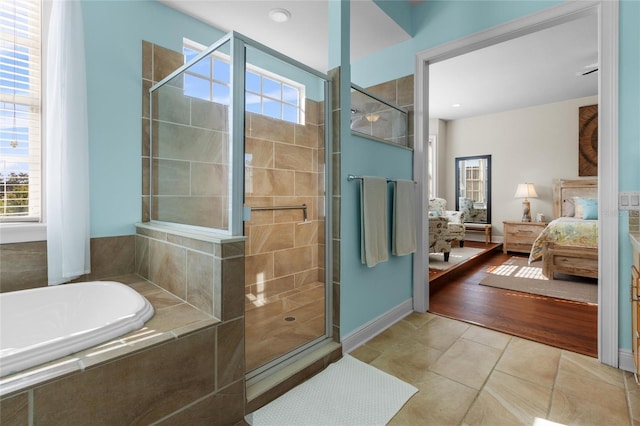 bathroom featuring plus walk in shower and hardwood / wood-style flooring