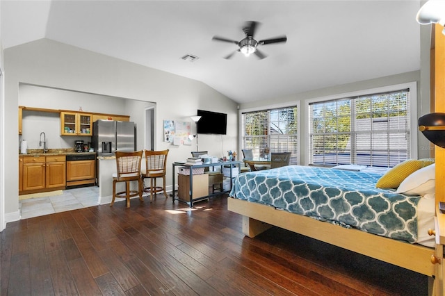 bedroom with stainless steel fridge, hardwood / wood-style flooring, and lofted ceiling