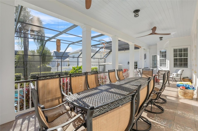 view of patio / terrace featuring ceiling fan and glass enclosure