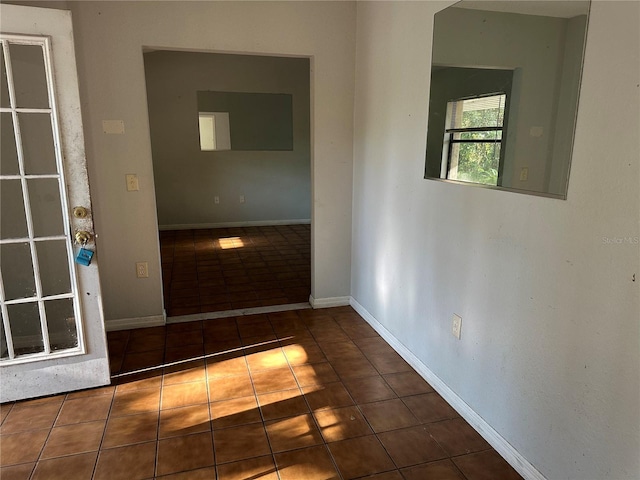 hall featuring dark tile patterned flooring