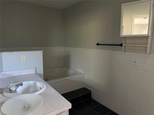 bathroom with tile patterned floors, a bathtub, tile walls, and vanity