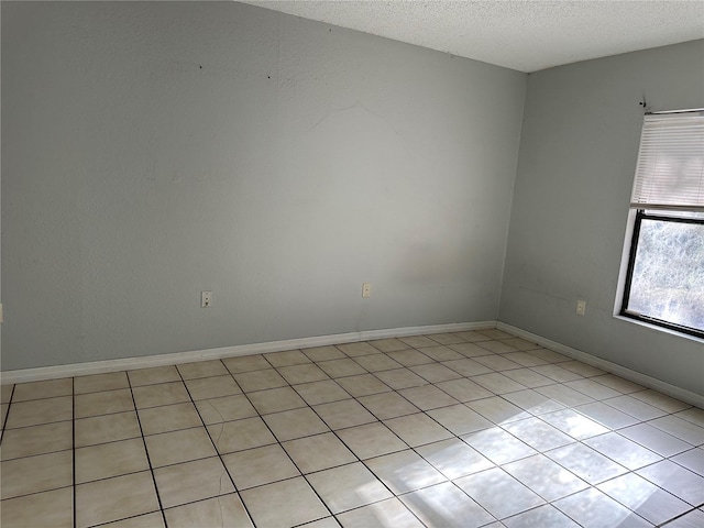 spare room with light tile patterned floors and a textured ceiling