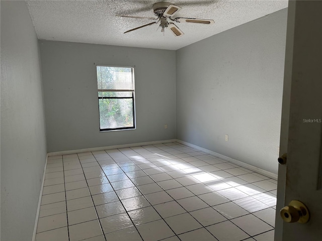 spare room with ceiling fan, light tile patterned floors, and a textured ceiling