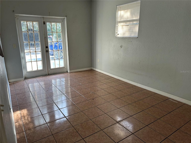 spare room featuring tile patterned flooring and french doors