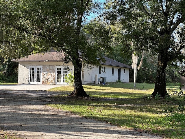 view of front of house featuring a front lawn and french doors