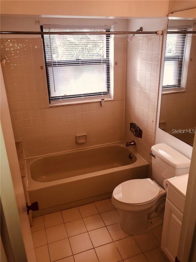 full bathroom with tile patterned floors, vanity, tiled shower / bath combo, and toilet