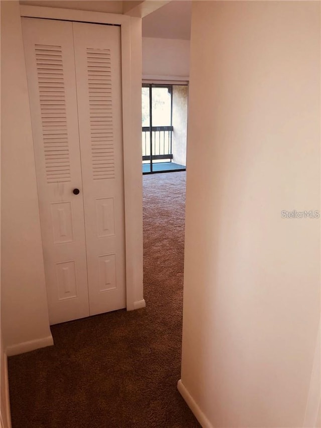 hallway featuring dark colored carpet