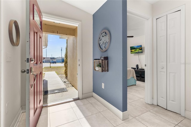 foyer featuring light tile patterned floors and vaulted ceiling