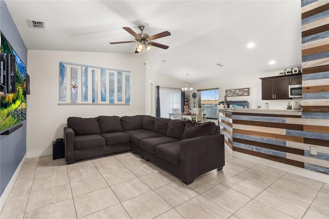 tiled living room featuring ceiling fan with notable chandelier and lofted ceiling